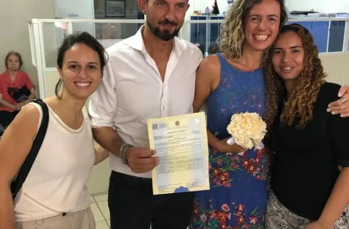 Recém casados com a certidão de casamento com interpretação juramentada.